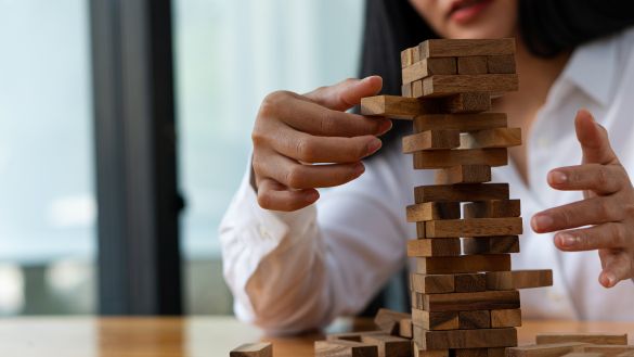 Women pulling wooden block from tower